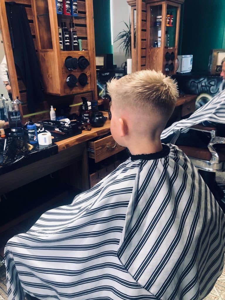 Blonder Herrenhaarschnitt mit sauberem Übergang von hinten